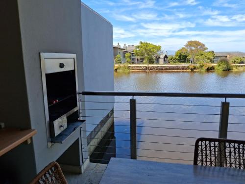 a balcony with a view of a river at Lakeside Apartment in Oubaai Golf Estate in George