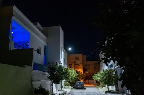 a street at night with a car driving down a street at CASABLU Apparte - Terrasse avec vue Sunset in Nabeul