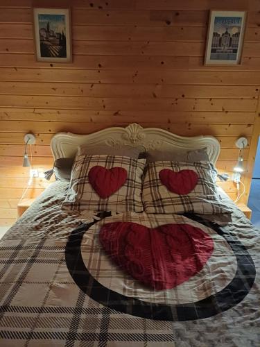 a bed with a comforter with hearts on it at Ambiance chalet in Prignac-et-Marcamps