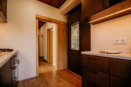 a kitchen with wooden cabinets and a counter top at Country Club - Sto Estevao in Benavente