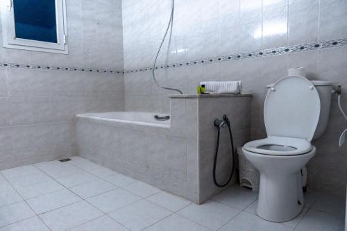 a white bathroom with a toilet and a bath tub at CASABLU Apparte - Terrasse avec vue Sunset in Nabeul