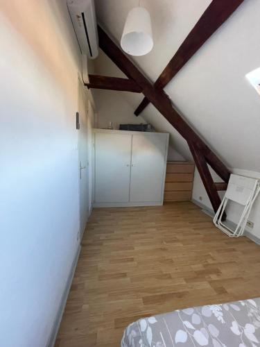 Cette chambre mansardée comprend un lit et un placard blanc. dans l'établissement CosyAppart Caudry, à Caudry