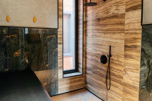 a shower in a bathroom with a wooden wall at SULO VIP Spa in Atyraū