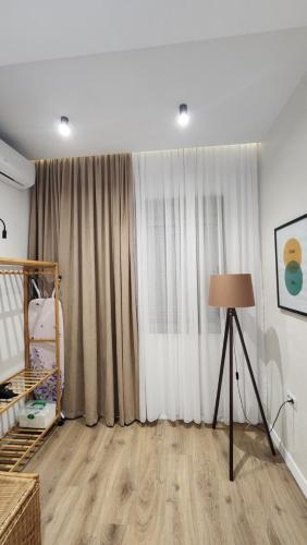 a living room with a large window and a lamp at 3S Apartments -Sea-Sun-Sky- in Sarandë