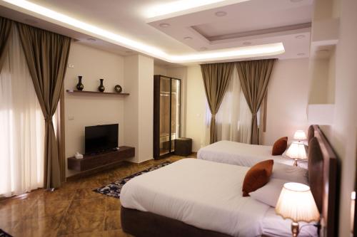 a hotel room with two beds and a television at Pyramids Sunshine View in Cairo