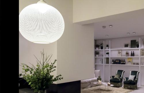 a living room with a large white pendant light at Talè Restaurant & Suite in Piedimonte Etneo