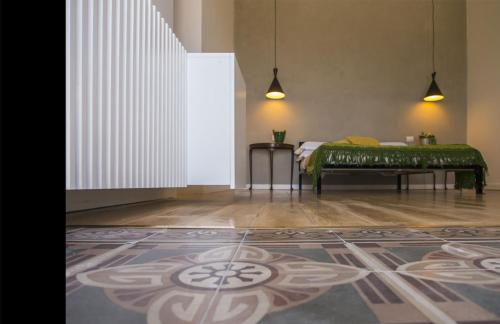 a room with a bed and a rug on the floor at Talè Restaurant & Suite in Piedimonte Etneo