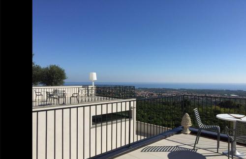a balcony with a table and chairs and the ocean at Talè Restaurant & Suite in Piedimonte Etneo