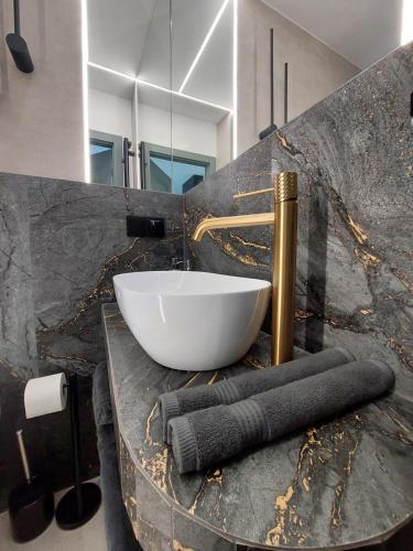 a bathroom with a sink and a bowl on a counter at Royal Smart Apartments Cracow in Krakow
