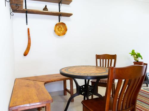 a dining room table with a wooden chair and a table and a tableweredktop at Perfect 2BR Airport Layover Transit Accommodation - High Speed WiFi 30mbps in Nairobi
