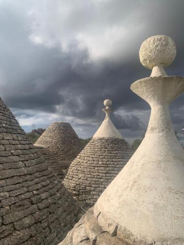 a view of some stone roofs with a cloudy sky at Vittò in Martina Franca