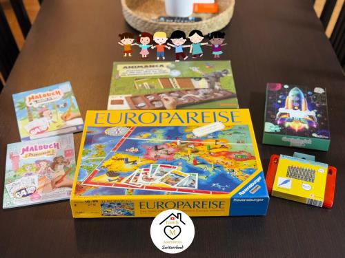a table topped with four boxes ofopolyassic games at Family M Apartments 2 in Kappel bei Olten