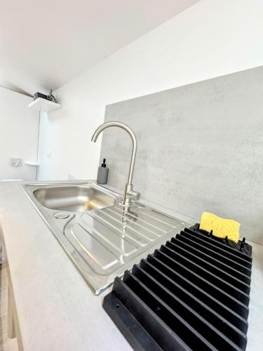 - un comptoir de cuisine avec un évier et un robinet dans l'établissement Le Rêve Bleu 1er Étage, à Abbeville