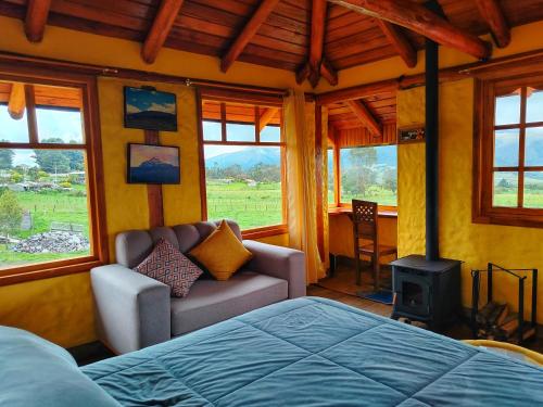a bedroom with a bed and a chair and a stove at Ruta de los volcanes in Machachi