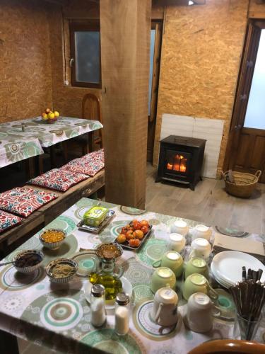una mesa con platos de comida y una chimenea en MARILLUNA aixoplucrural, en Montblanquet