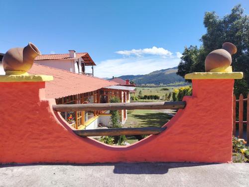a fence with a view of a house at Ruta de los volcanes in Machachi