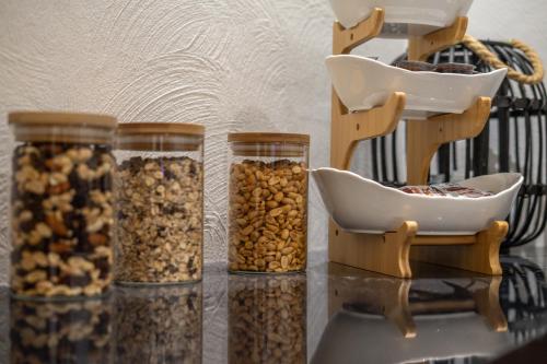 four glass jars filled with nuts on a table at Boutiquehotel - Michl in Sautens