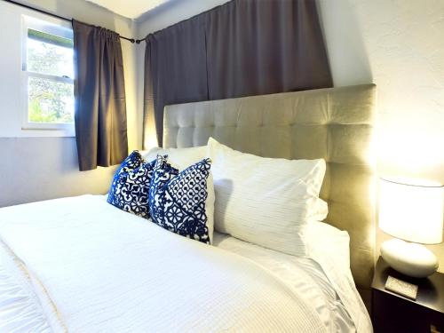 a bedroom with a white bed with pillows and a window at Modern Boho Retreat in Corvallis