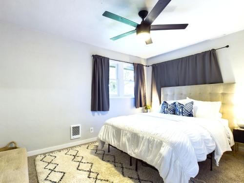 a bedroom with a bed with a ceiling fan at Modern Boho Retreat in Corvallis