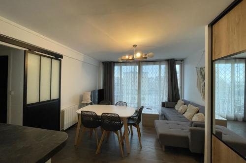 un salon avec une table et un canapé dans l'établissement Le thieullent, au Havre