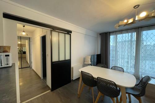 une cuisine et une salle à manger avec une table et des chaises dans l'établissement Le thieullent, au Havre
