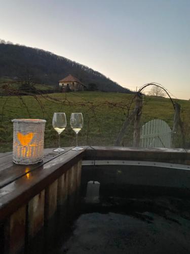 two wine glasses and a basket sitting on a ledge at Somlói Provence in Doba