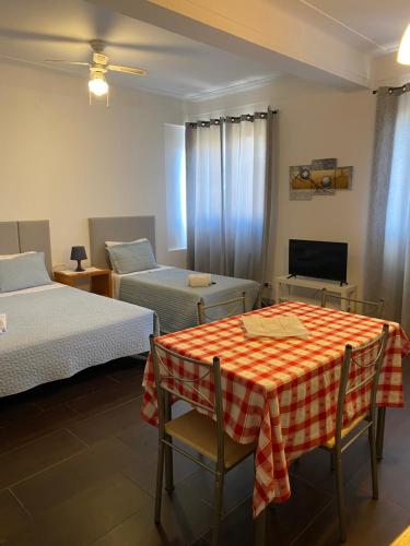 a room with two beds and a table and a tv at Guest house D. Filipe I in Porto
