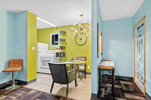 a dining room with yellow and blue walls and a table and chairs at Blue Bell Apartment Hotel in Fort Lauderdale