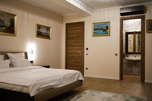 a bedroom with a bed and a bathroom with a sink at Therme Criss in Baloteşti