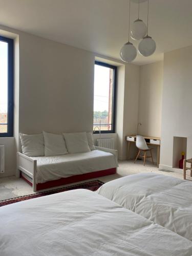 - une chambre blanche avec 2 lits et un bureau dans l'établissement Château Batsères, à Landiras