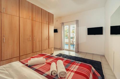 una camera da letto con letto, asciugamani e armadi di Crystal Cherry Apartment a Preveza