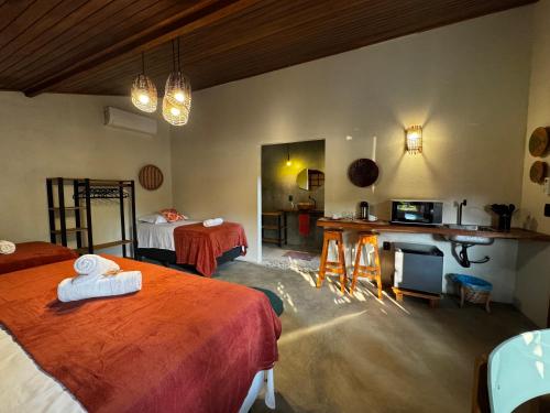 a room with two beds and a kitchen with a table at Pousada Ocazum Ilha do Amor in Alter do Chao