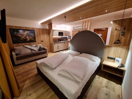 a bedroom with a large bed and a couch at Hotel Mondschein in Sesto