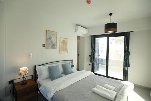 1 dormitorio con 1 cama con sábanas blancas y almohadas azules en Blossom House-At the foot of the Acroplis and Parking available, en Atenas