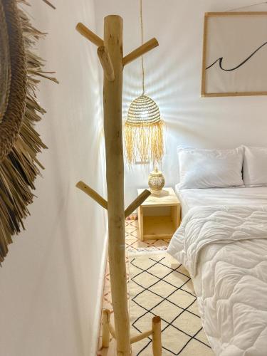 a wooden cross in a bedroom next to a bed at Eco Bay Surf House in Agadir