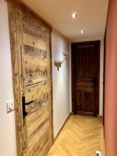- une porte en bois dans une chambre avec couloir dans l'établissement Appartement Bourg Saint Maurice, à Bourg-Saint-Maurice