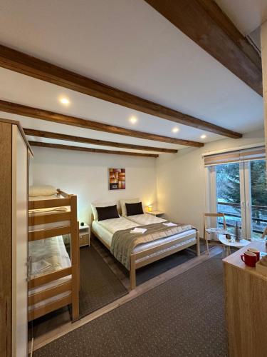 a bedroom with a large bed and a window at Apartman - Sobe Tiha Luka, Bjelašnica in Bjelašnica