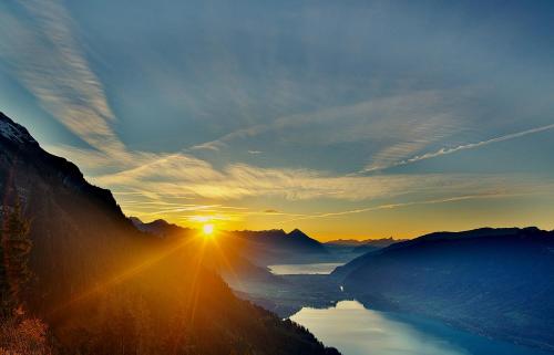 a view of the sun setting over a lake at Family-Apartment Du Lac in Iseltwald