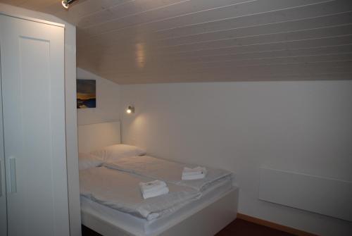 ein kleines Schlafzimmer mit einem Bett in einem Zimmer in der Unterkunft Family-Apartment Du Lac in Iseltwald