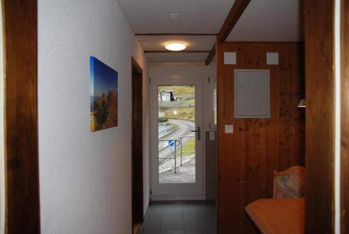 a hallway with a door leading to a balcony at Family-Apartment Du Lac in Iseltwald
