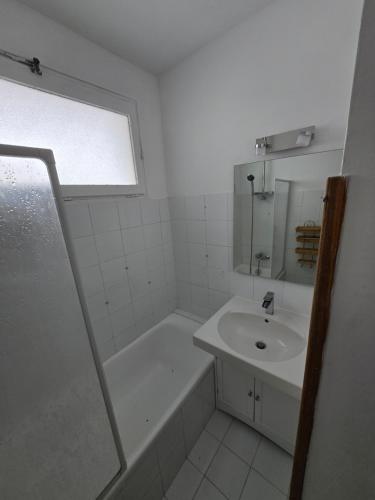 une salle de bain blanche avec un lavabo et une douche dans l'établissement Pied des pistes app 5 personnes, à La Clusaz