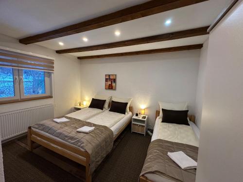 a bedroom with two beds and a window at Apartman - Sobe Tiha Luka, Bjelašnica in Bjelašnica