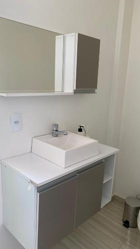 a bathroom with a white sink and a mirror at Sobrado Vila Industrial in Toledo