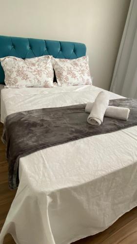 a white bed with a blue headboard and white sheets at Sobrado Vila Industrial in Toledo