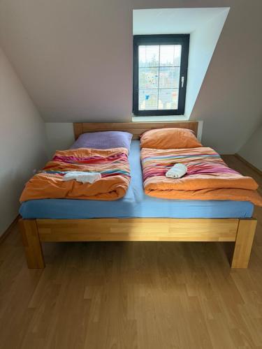 a bed in a small room with a window at Mezonet v Tatranskej Lomnici in Tatranská Lomnica