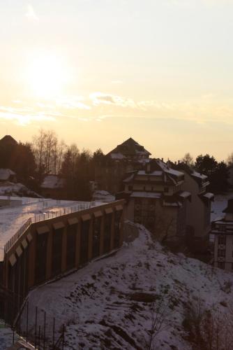 a snow covered road with a fence and buildings at Silvani Kop NLux67, Milmari Apartments & Spa in Kopaonik