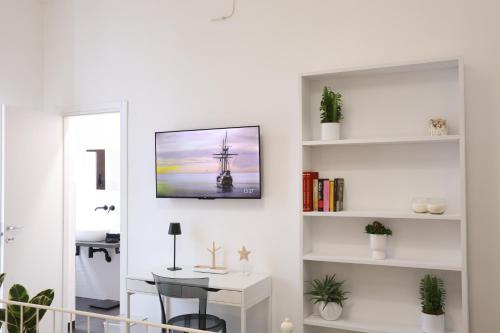 a living room with a table and a tv on a wall at Casa Alessandra in Nardò