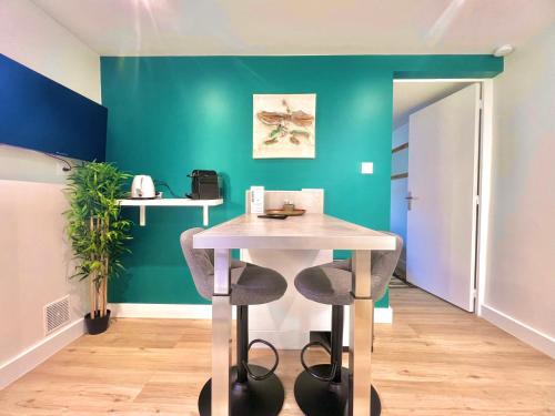 - une table dans une pièce dotée d'un mur vert dans l'établissement Petit cocon avec clim, centre-ville & proche gare, à Marmande