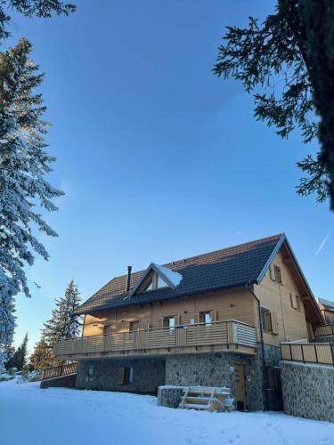a large wooden house in the snow at Rogla Alpina Residence in Zreče
