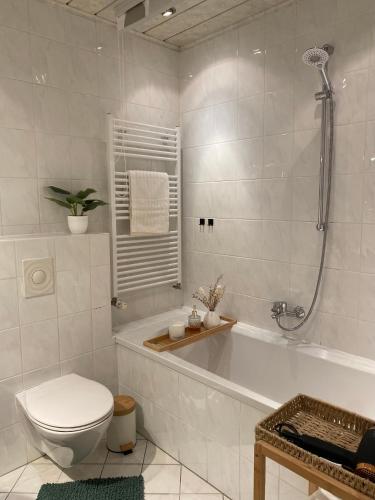 ein weißes Badezimmer mit Toilette und Badewanne in der Unterkunft CityBude in Gerolstein